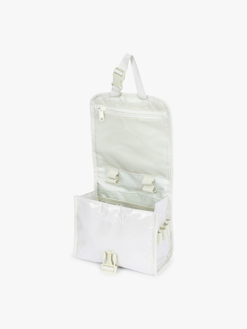 Opened CALPAK Terra Hanging Toiletry Bag in shiny white Moonbeam with front buckle