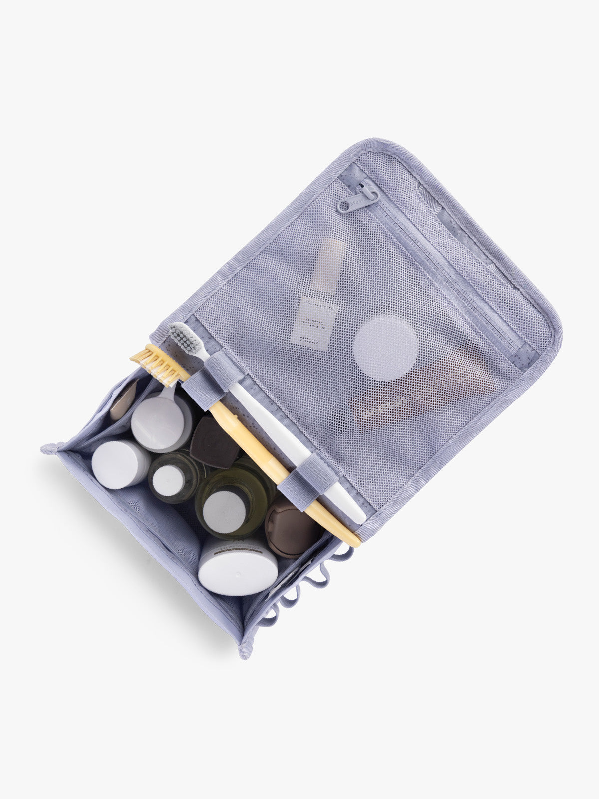 Toiletry items into CALPAK Terra Hanging Toiletry Bag in light purple Sea Glass with front buckle; THY2201-SEA-GLASS