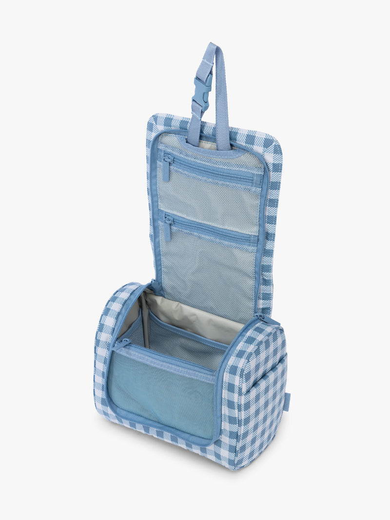 Opened view of CALPAK Luka Hanging Toiletry Bag in white and blue gingham print in French Blue Gingham