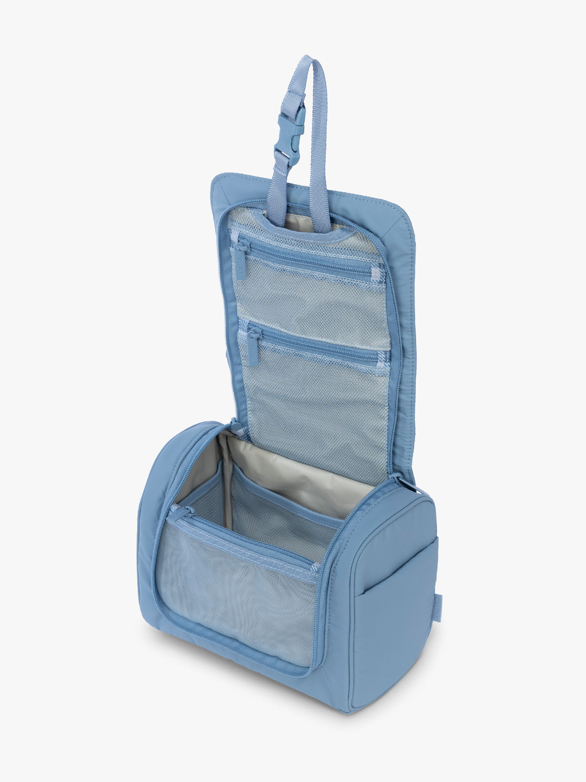 Opened view of the CALPAK Luka Hanging Toiletry Bag in light blue French Blue; TLH2301-FRENCH-BLUE