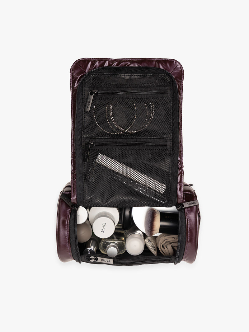 Items in the CALPAK Luka Hanging Toiletry Bag in maroon Glazed Dark Cherry