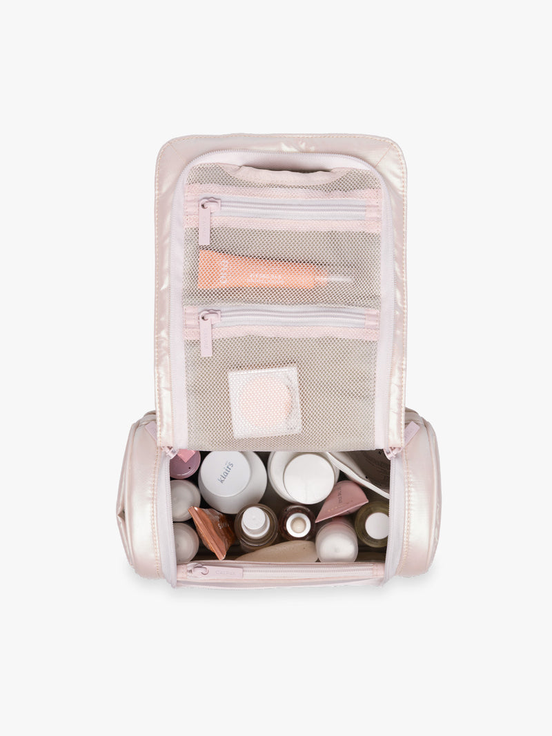 Items in CALPAK Luka Hanging Toiletry Bag in light pink shiny Pearlescent