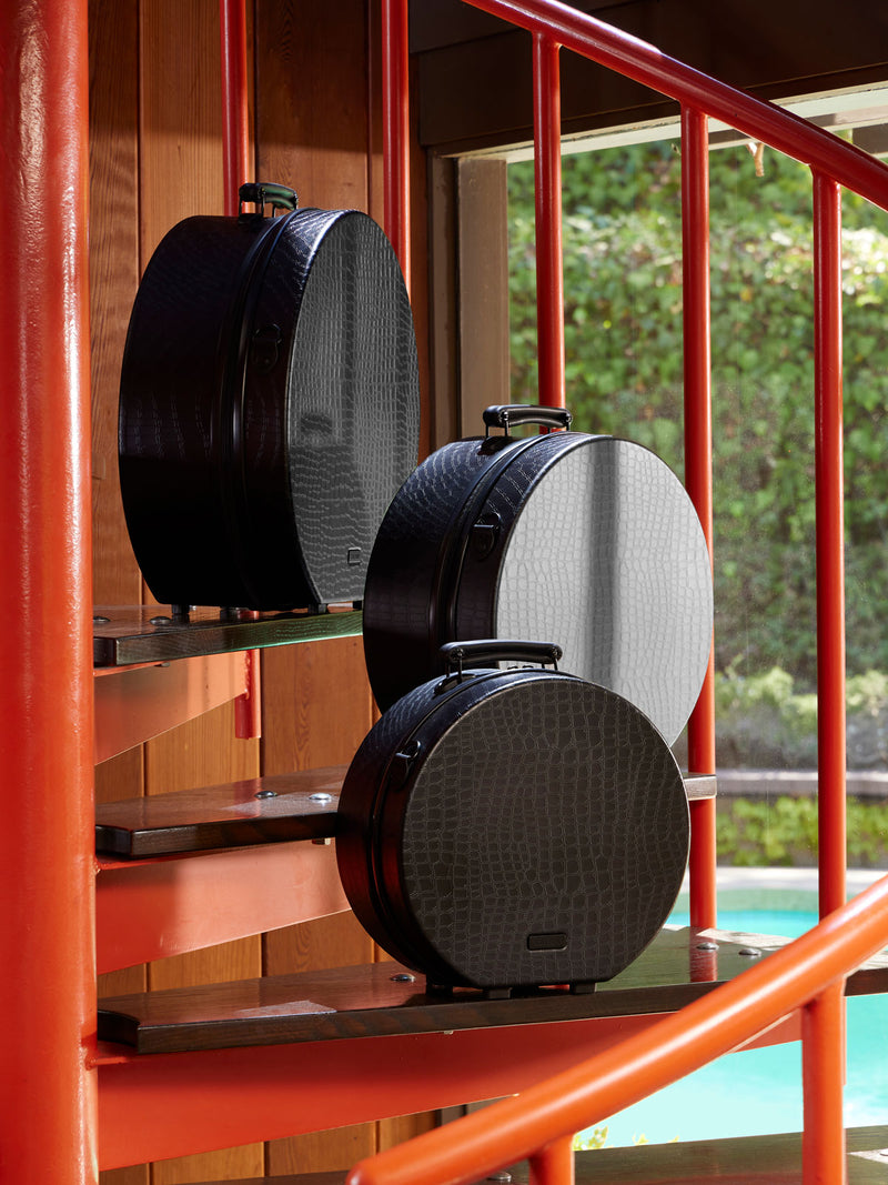 CALPAK TRNK Large Hat Box in block. 3 different sizes of hat boxes on orange stairwell
