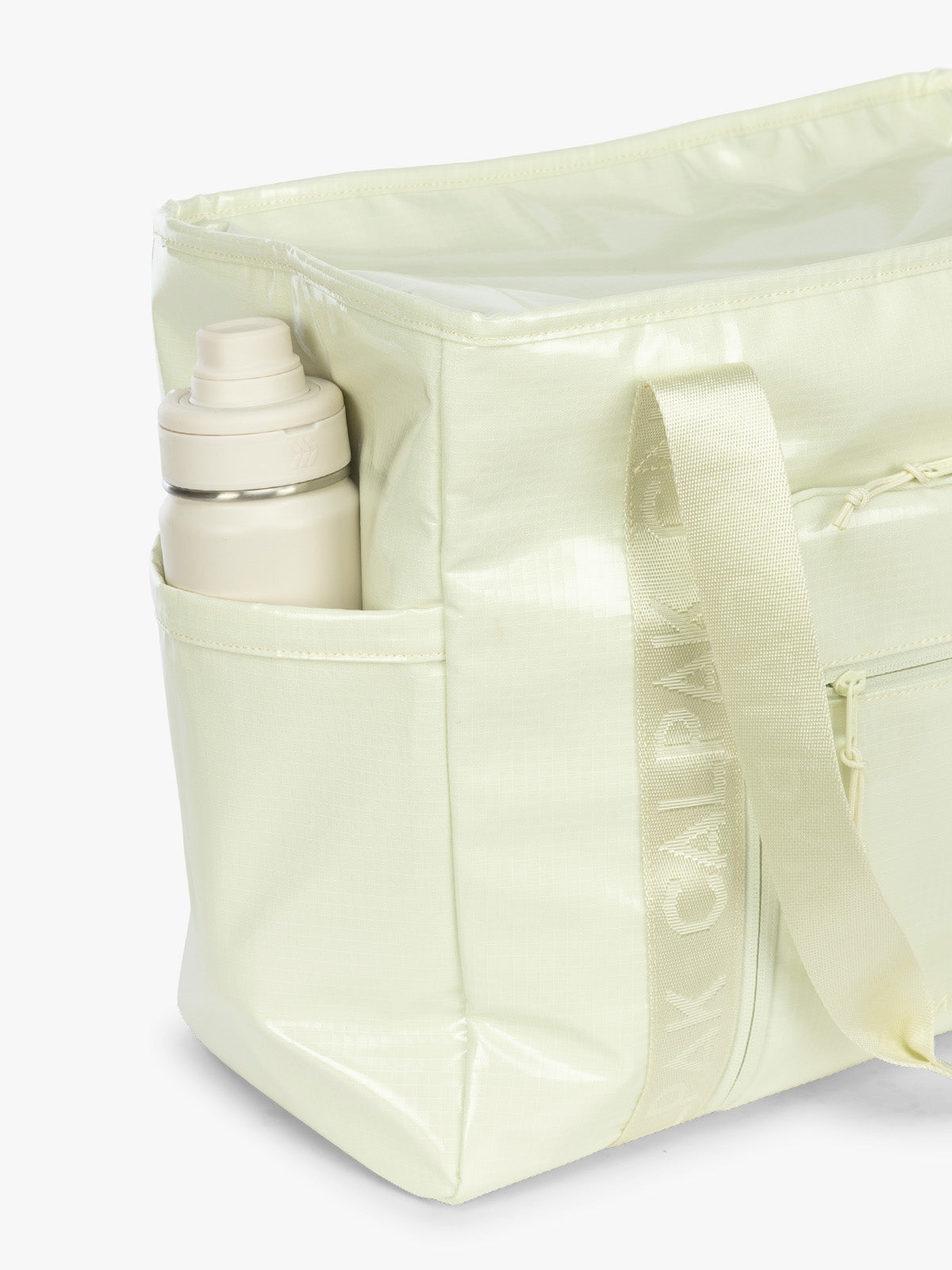 Side water bottle pocket of the CALPAK Terra 35L Tote Bag with multiple pockets and shoulder straps in shiny light green Celadon on a white background; TTO2401-CELADON