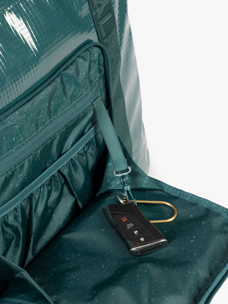 Key line of CALPAK Terra 35L Tote Bag with zippers in blue green Kale on a white background