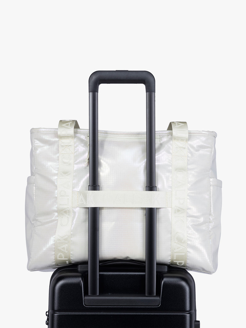 Trolley sleeve component of CALPAK Terra 35L Tote Bag with multiple pockets and shoulder straps in shiny white Moonbeam on a white background