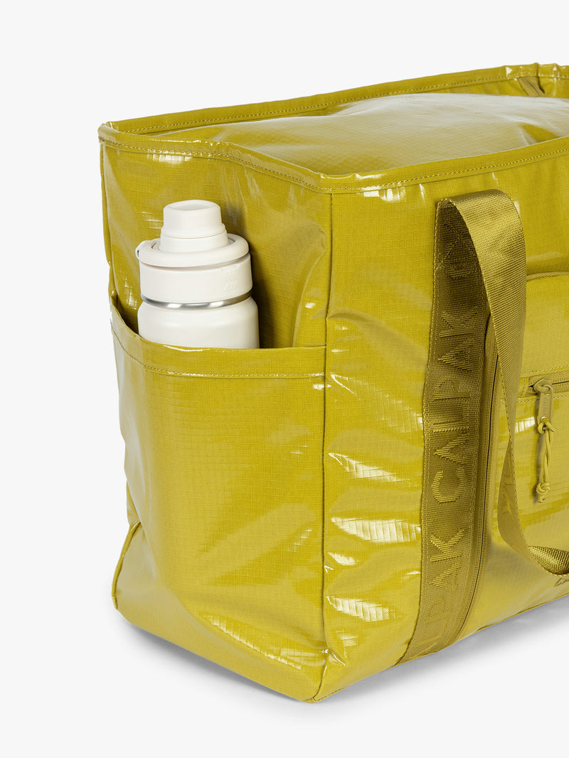 Side water bottle holder of CALPAK Terra 35L Tote Bag with zippers in yellow green Wasabi on a white background