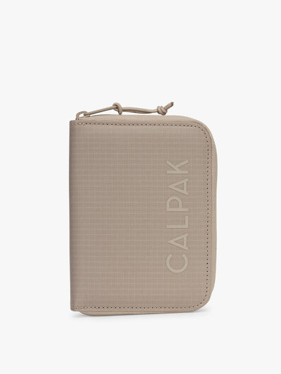 CALPAK Terra Zippered Passport Wallet in beige Stone front view; ATPW2501-STONE view 1