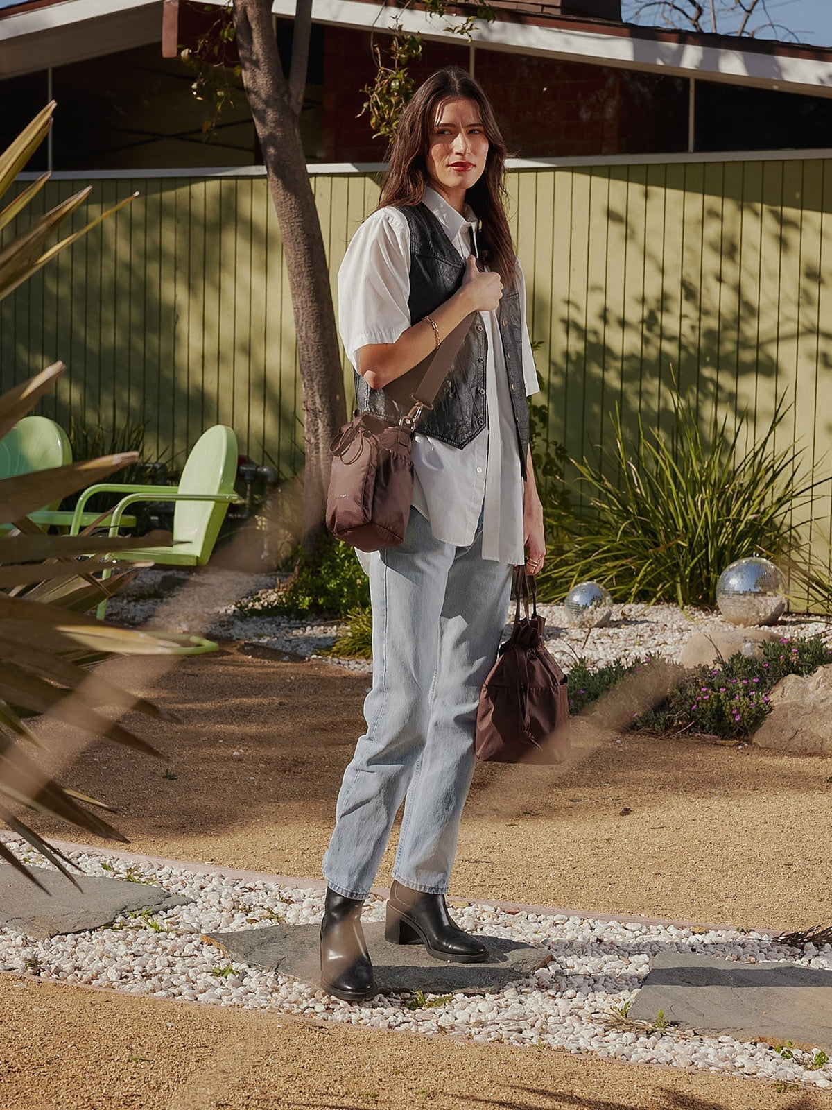 Model carrying CALPAK Water Bottle Holder with detachable sling and zipped front pocket in walnut brown; AWH2101-WALNUT