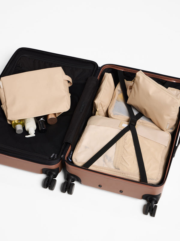 Beige CALPAK waterproof zippered pouch set of 3 inside CALPAK Hue Carry On Luggage