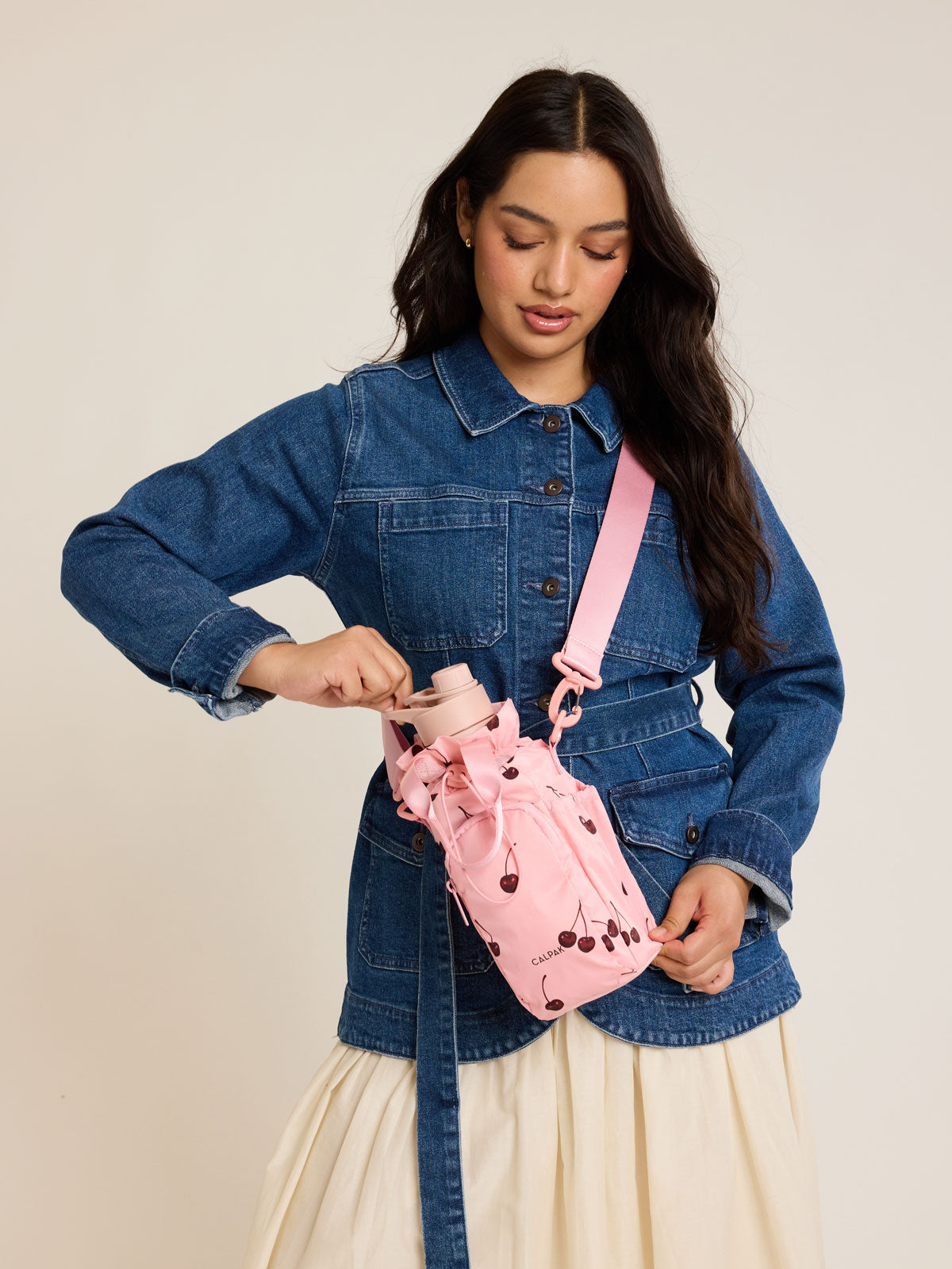 Model with CALPAK Water Bottle Holder in Oatmeal Chery in pink with cherry pattern; AWH2101-BLOSSOM-CHERRY