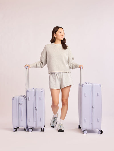 CALPAK Ambeur three piece luggage set in carry on, medium, and large sizes in light purple lavender with handles and spinner wheels on a white background; LAM3000-SEA-GLASS view 2