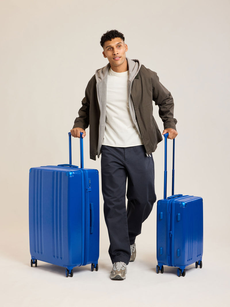 Model with CALPAK dark blue Cobalt 2pc Luggage Set