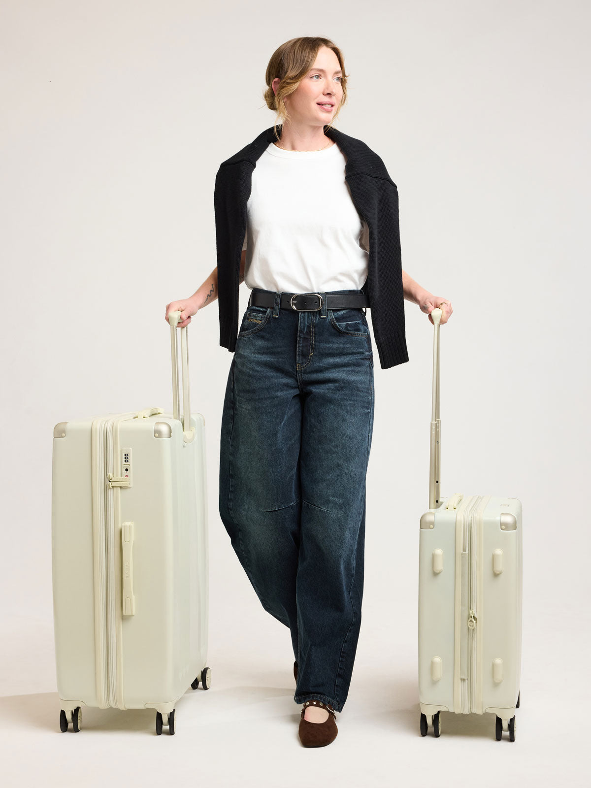 Woman with CALPAK Ambeur 2 piece Luggage Set in light green Celadon; LAM2000-CELADON