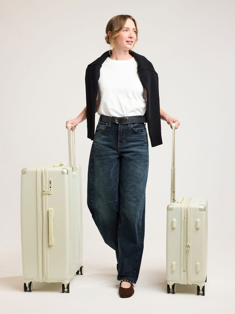 Woman with CALPAK Ambeur 2 piece Luggage Set in light green Celadon