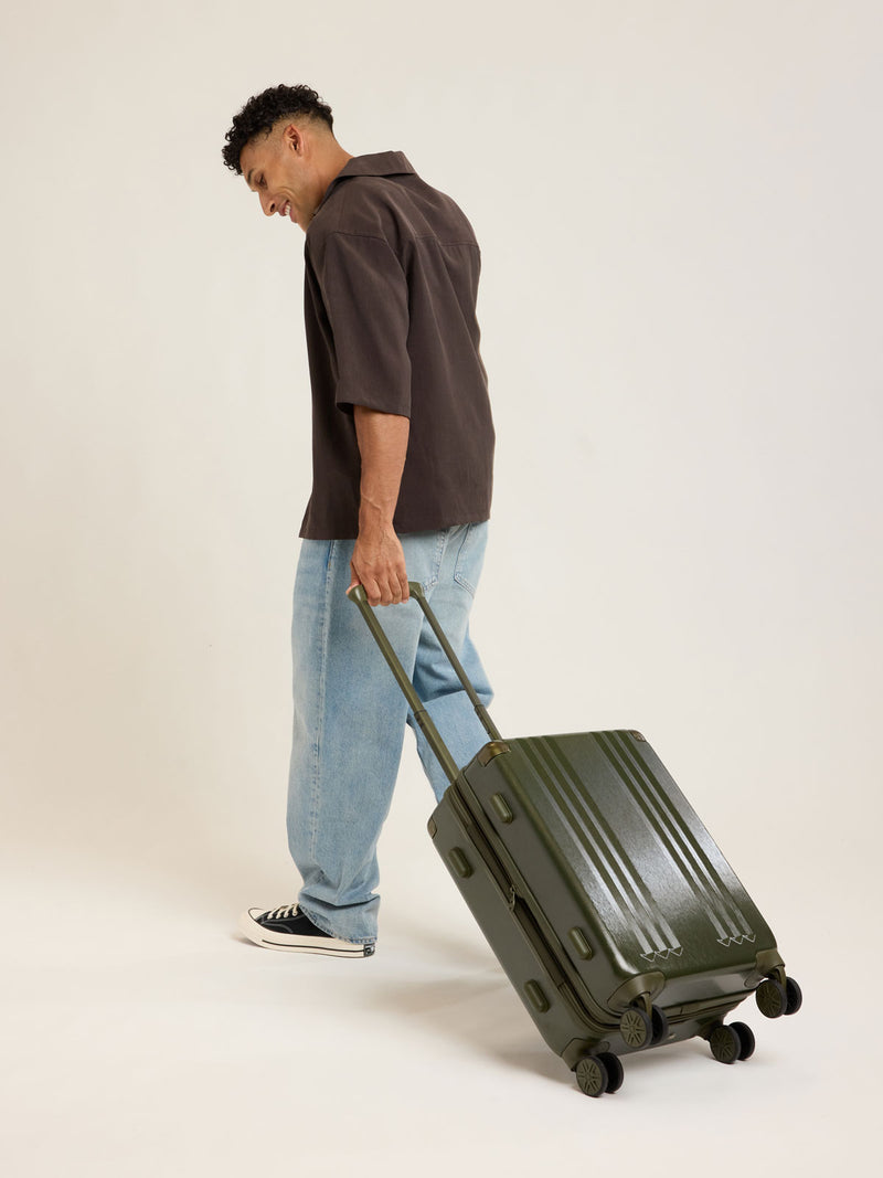 Model with CALPAK Ambeur Carry On Luggage in dark green Pine