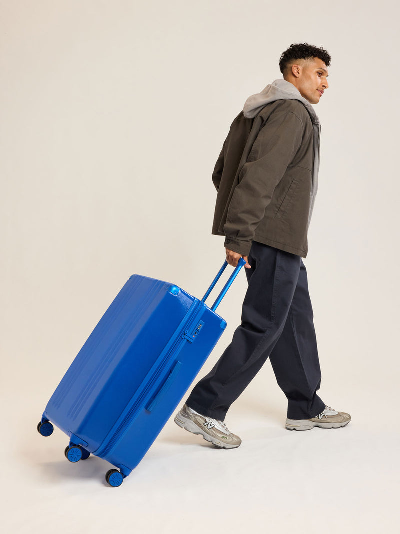 Model with CALPAK Ambeur Large Luggage in dark blue Cobalt