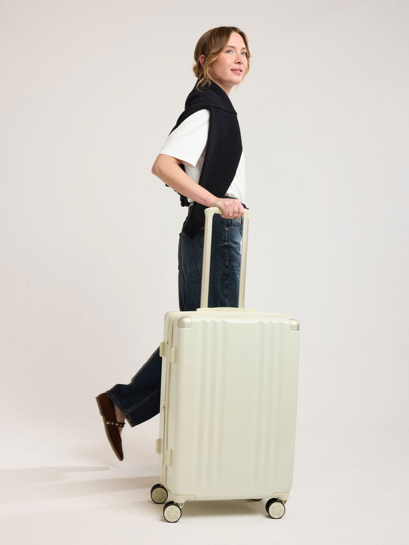 Woman with CALPAK Ambeur Medium Luggage in light green Celadon