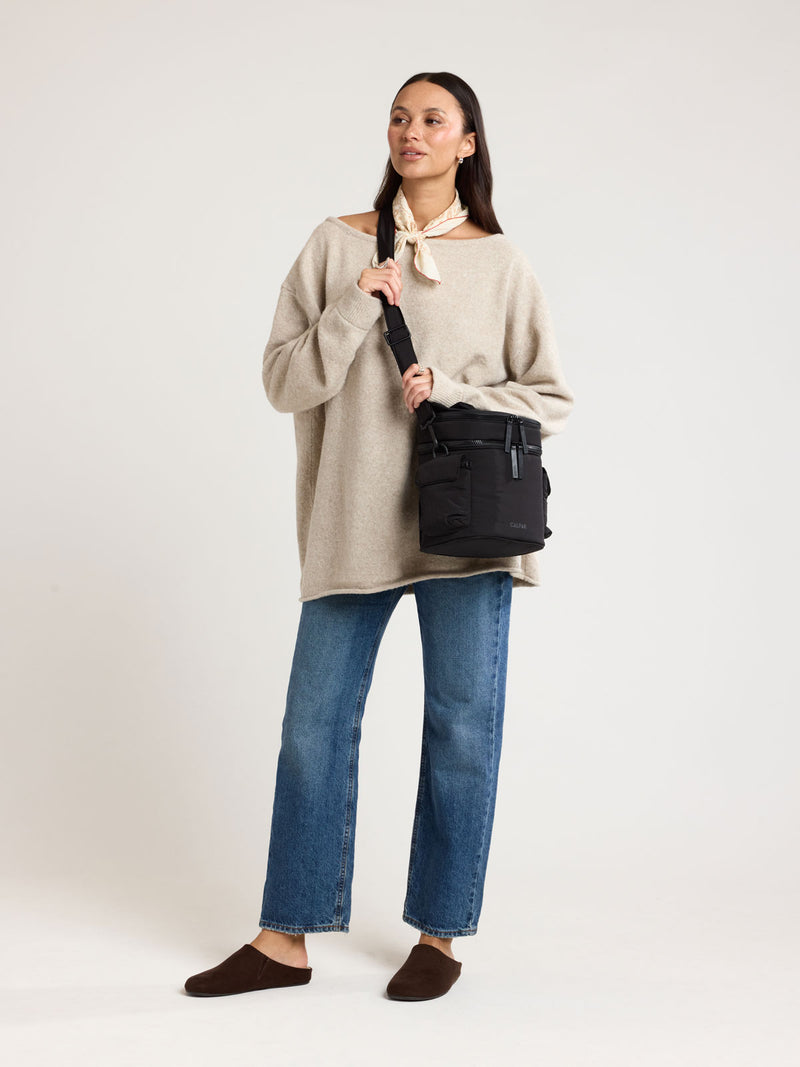 Woman wearing CALPAK Insulated Baby Bottle Bag in Black