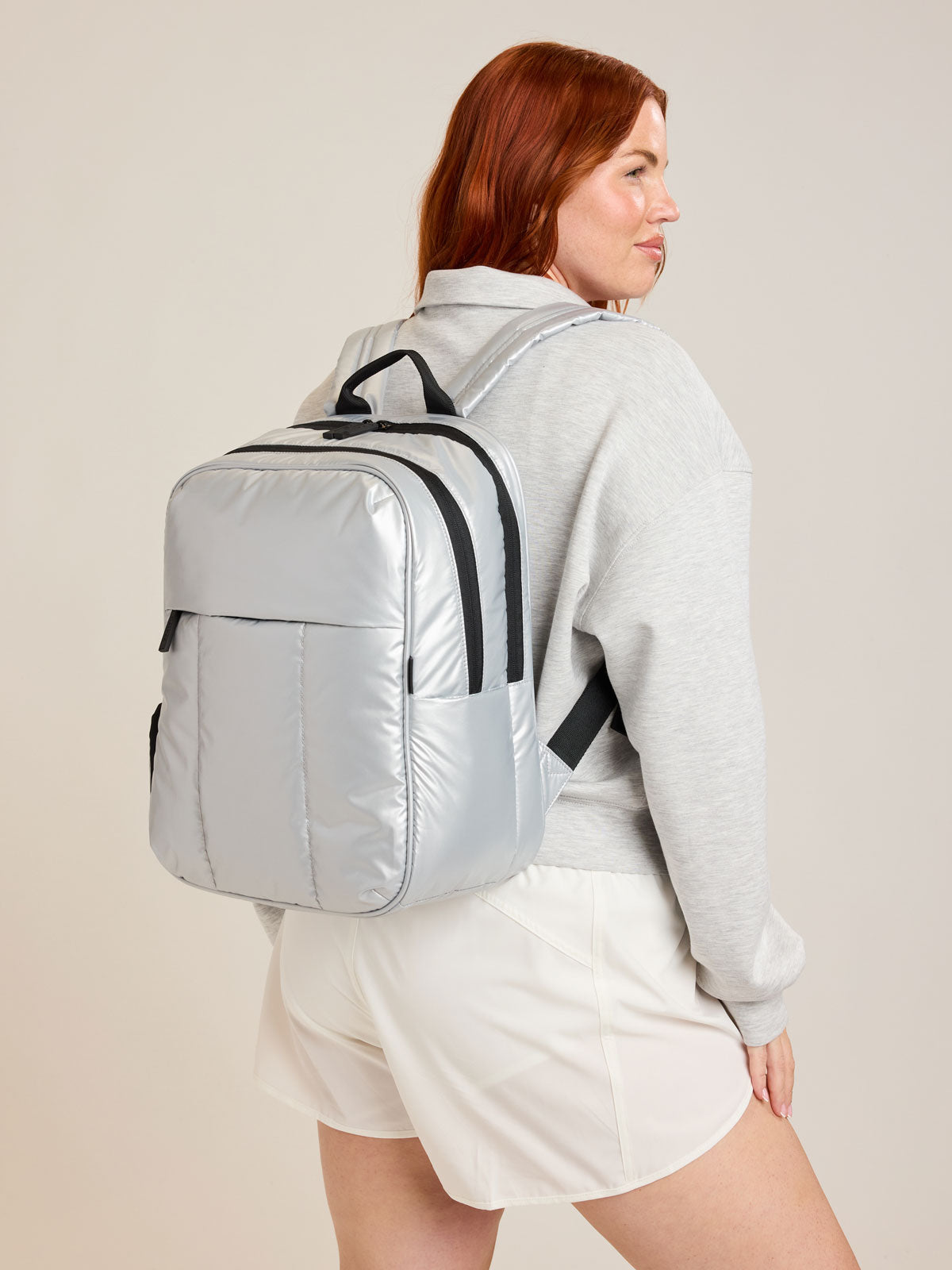 Model wearing CALPAK Luka Backpack in Silver; BPL2001-SILVER