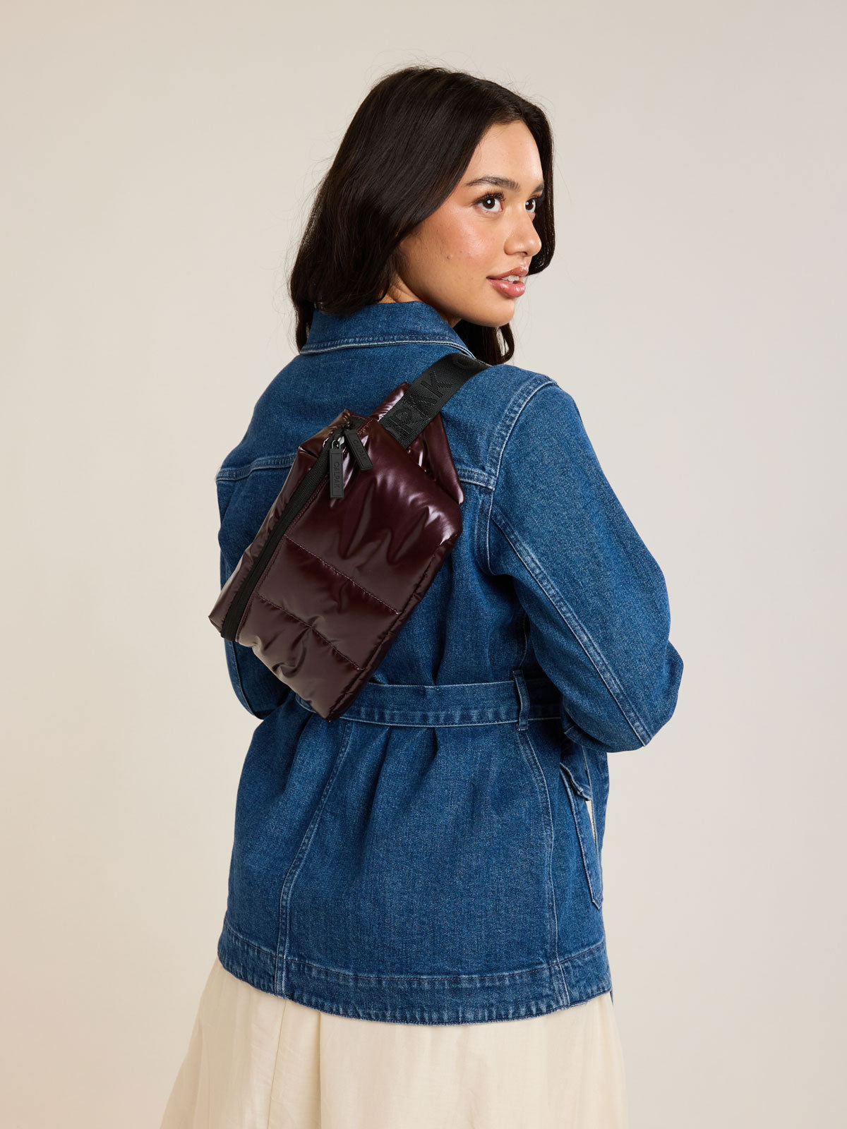 Model with CALPAK Luka Belt Bag in maroon Glazed Dark Cherry; BB1901-GLAZED-DARK-CHERRY