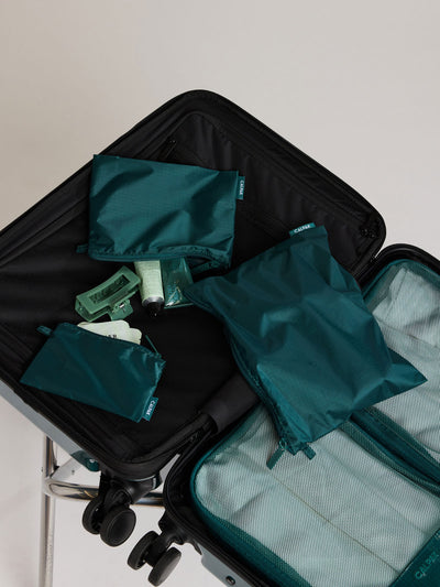 Three dark green teal Kale CALPAK Compakt Zippered pouches of different sizes, arranged in a fan-like layout on a clean white background; KZB2001-KALE view 2
