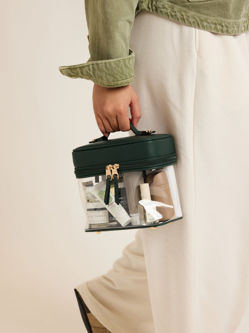 Model with CALPAK Clear Train Case in dark green Emerald