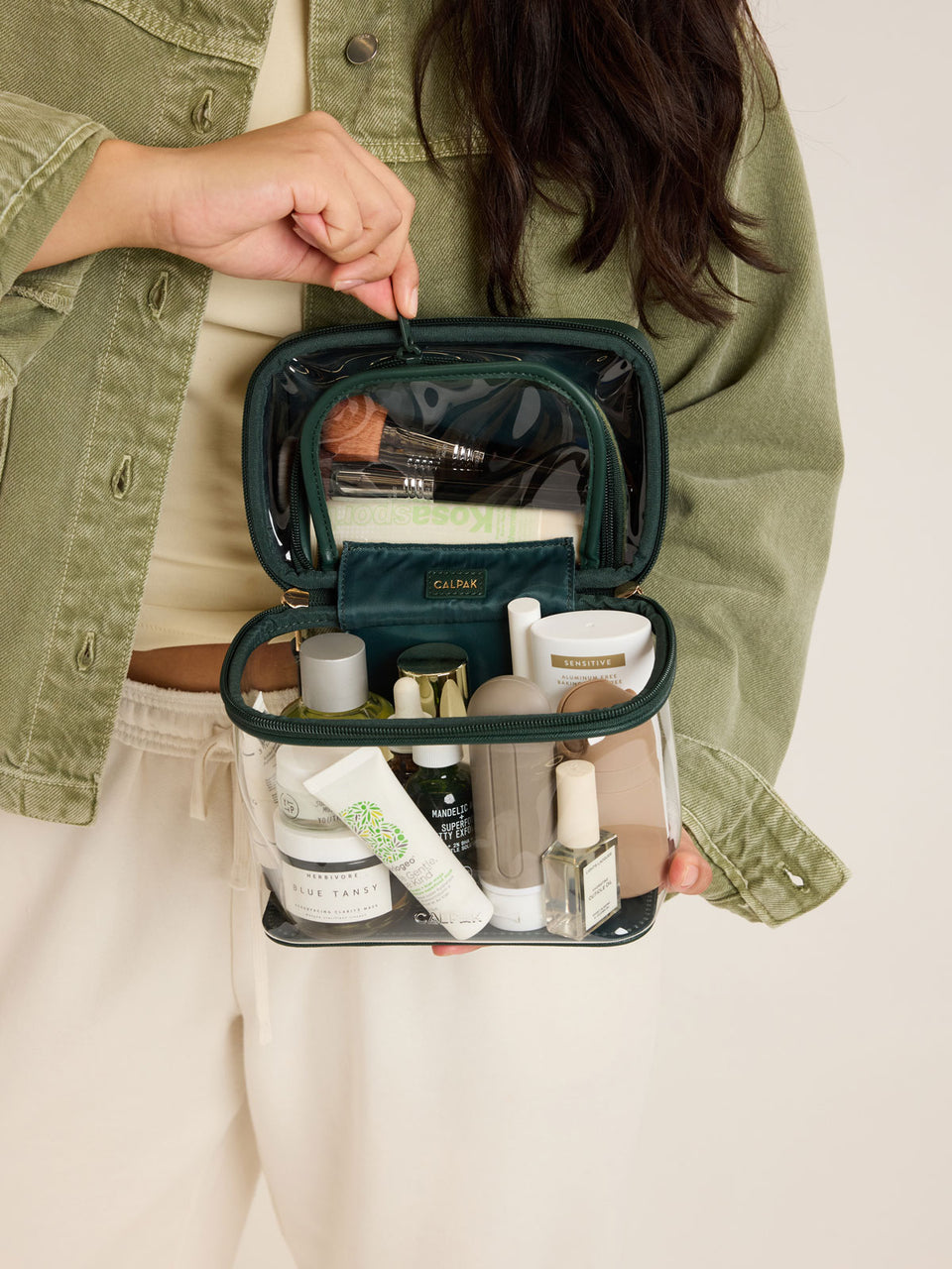 Model with the CALPAK Clear Train Case in dark green Emerald; CTC2401-EMERALD