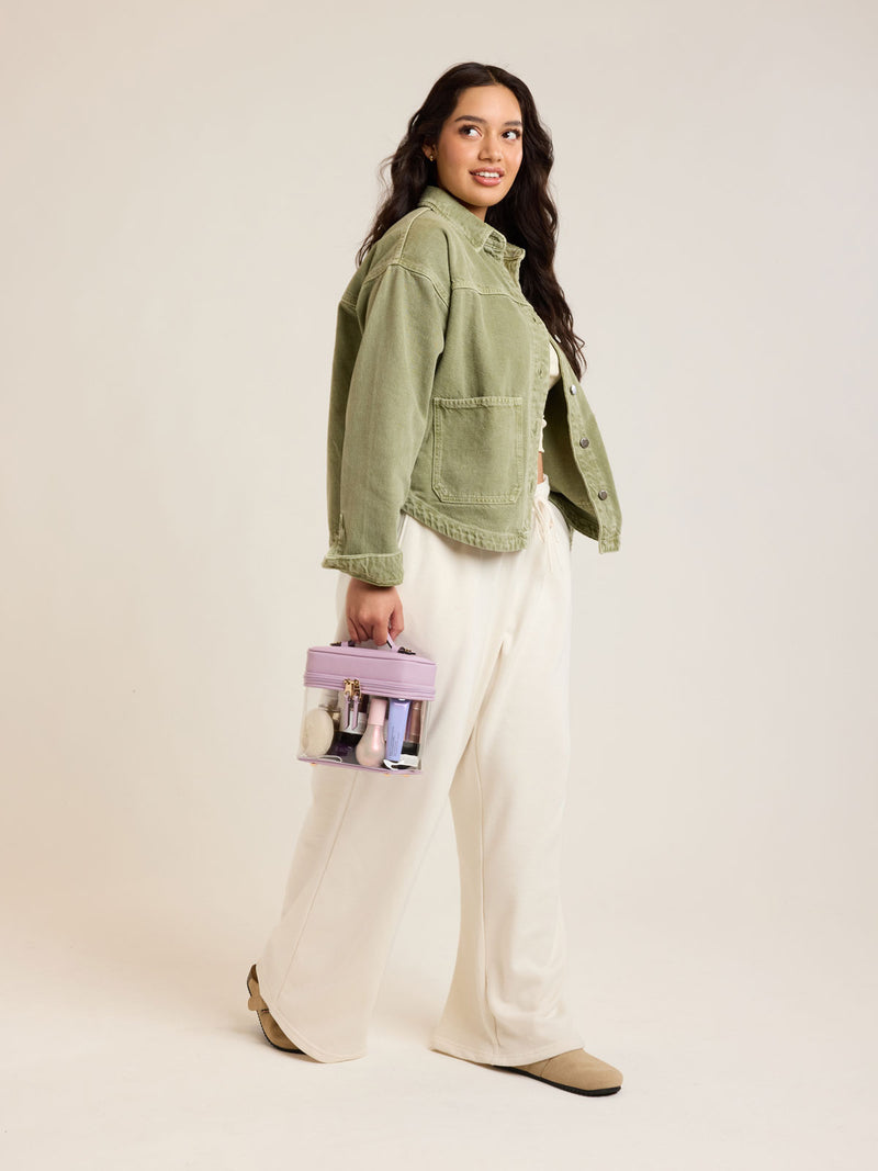 Model with CALPAK Clear Train Case in purple lavender