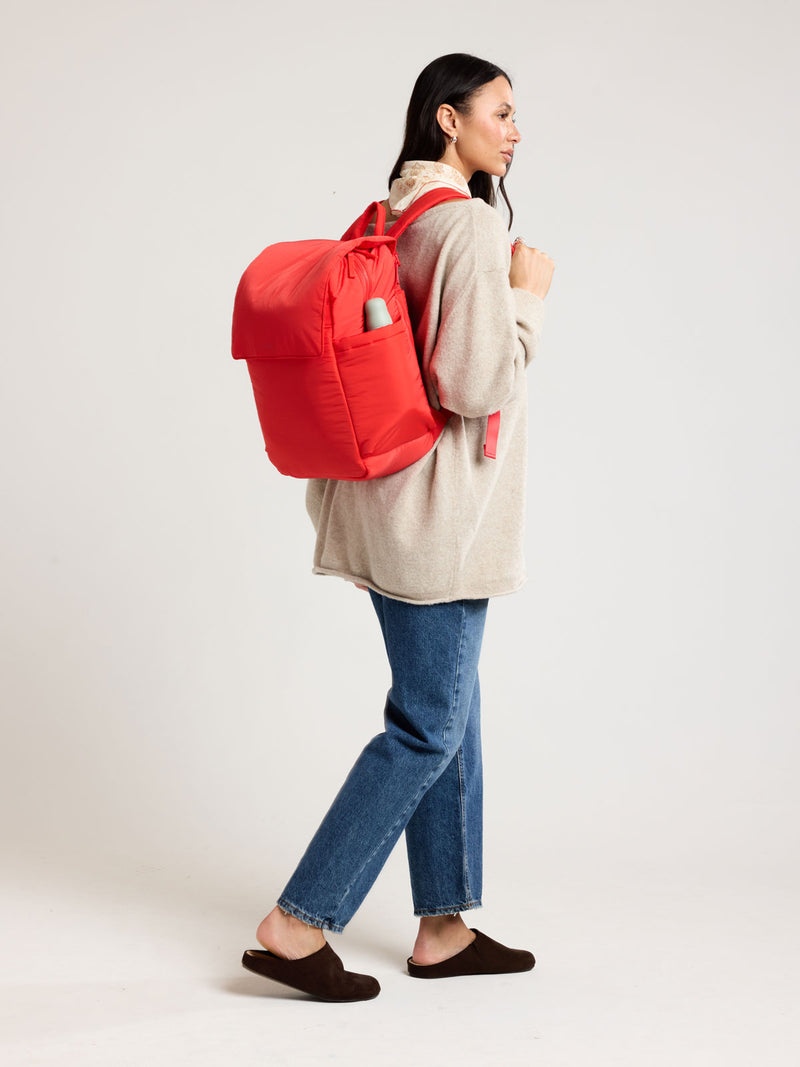 Woman wearing CALPAK Diaper Backpack in red Tomato