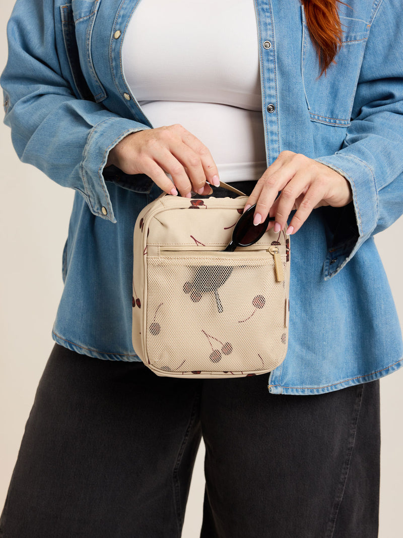 Model with CALPAK Everything Cube beige with cherry print Oatmeal Pink