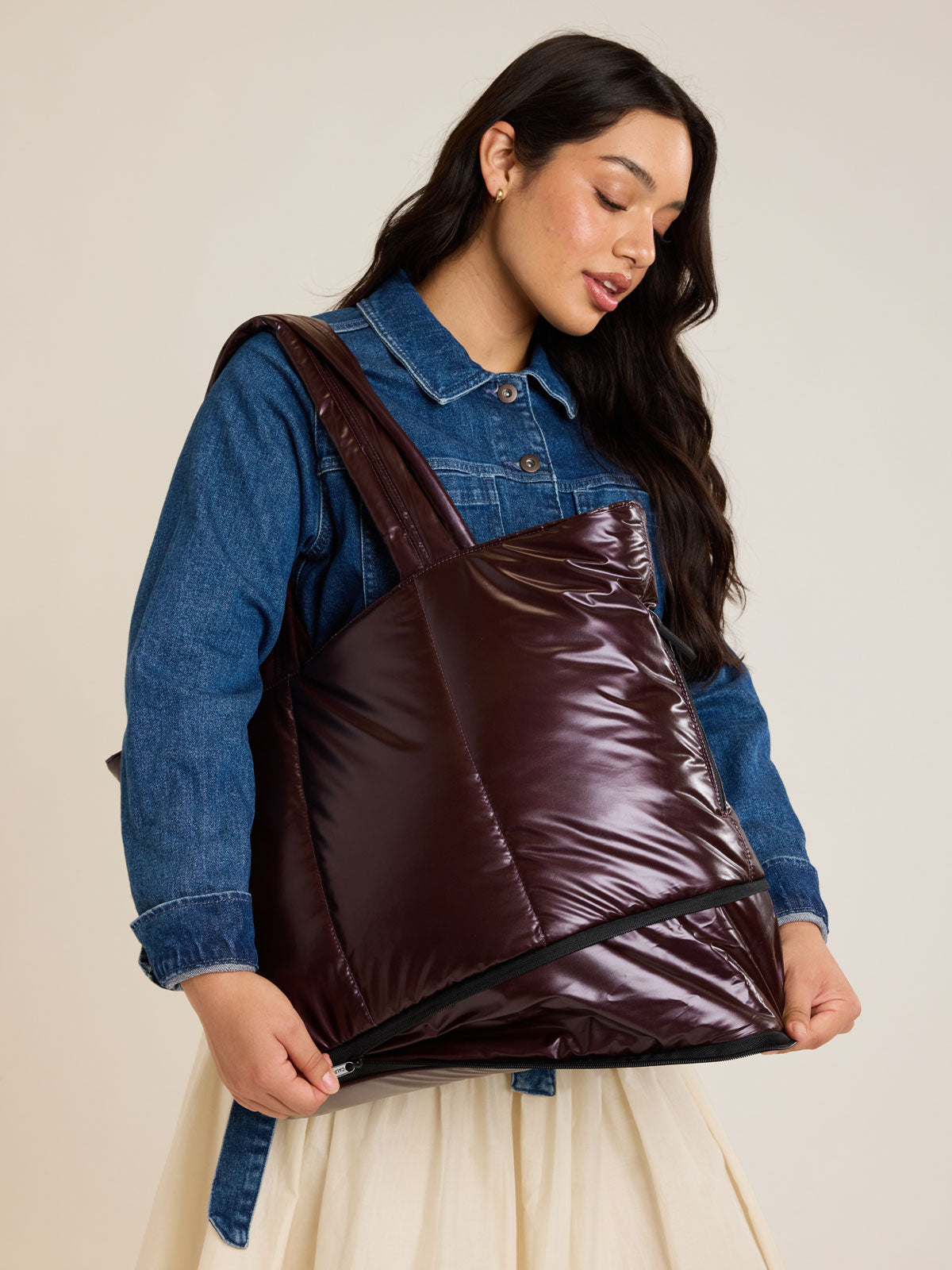 Model expanding the CALPAK Luka Expandable Tote in maroon Dark Cherry; ALT2201-GLAZED-DARK-CHERRY