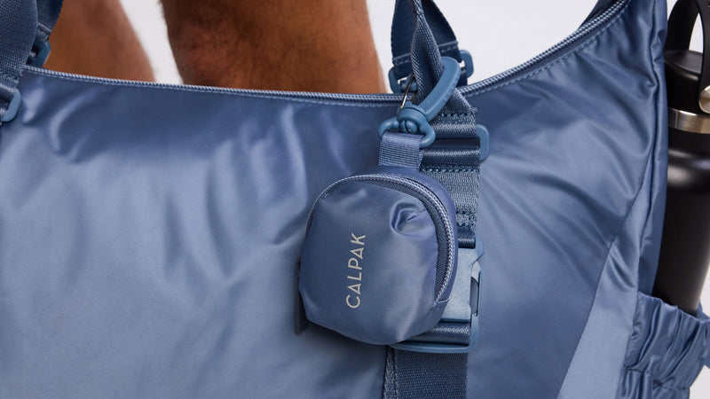 CALPAK Fit Bag Charm in blue Indigo clipped on bag