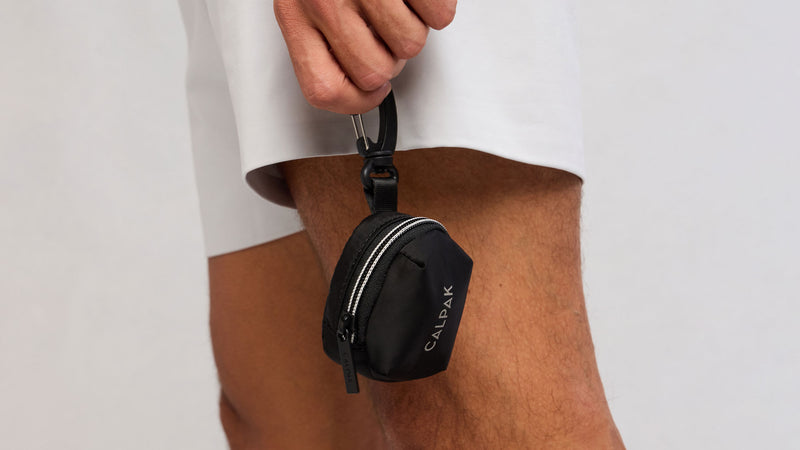 CALPAK Fit Bag Charm in Black being held by model