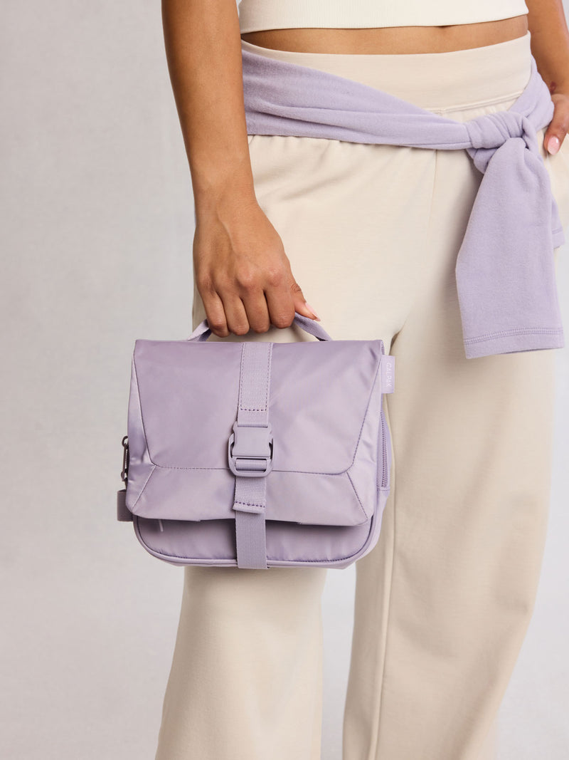 Model holding CALPAK Fit Hanging Dopp Kit in purple Iris