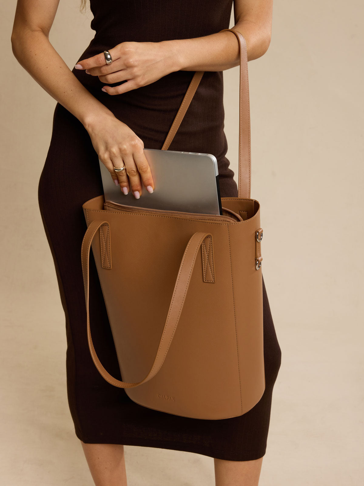 Model with CALPAK Haven 14 inch Laptop Bucket Bag in brown Toffee front view; ABU2501-TOFFEE