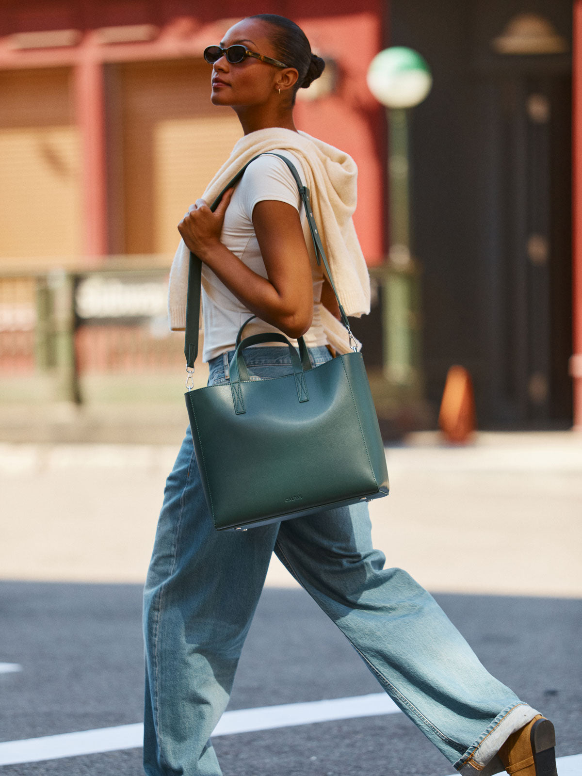 Model wearing the CALPAK Haven 15 inch Laptop Tote in dark green Forest; ATS2501-FOREST