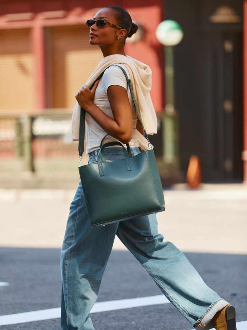 Model wearing the CALPAK Haven 15 inch Laptop Tote in dark green Forest