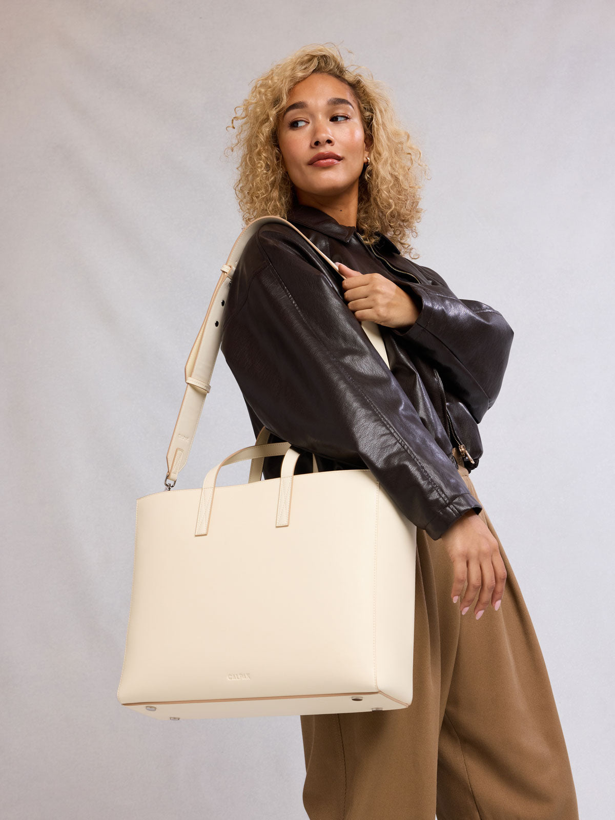 Model with CALPAK Haven 16" Laptop Tote in beige Buttercream; ATO2102-BUTTERCREAM