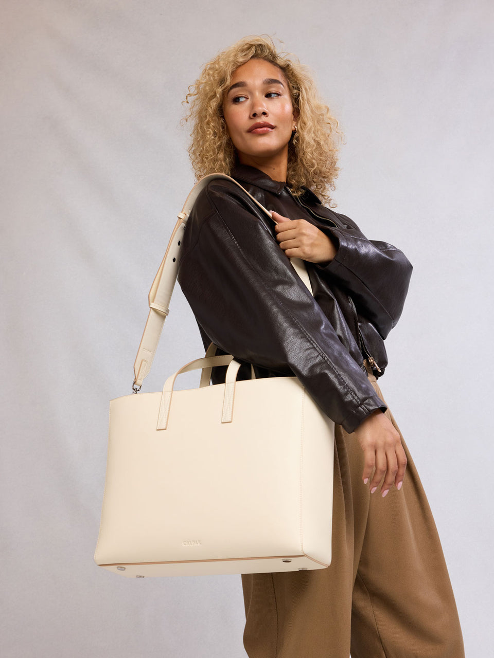 Model with CALPAK Haven 16" Laptop Tote in beige Buttercream; ATO2102-BUTTERCREAM