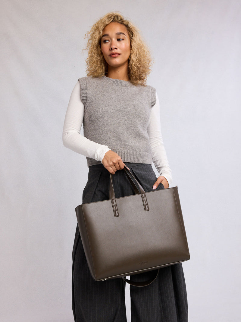 Model wearing CALPAK Haven 16" Laptop Tote in dark brown Mushroom