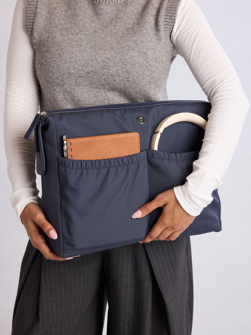 Modle holding the removeable insert of CALPAK Haven 16" Laptop Tote in dark blue Navy