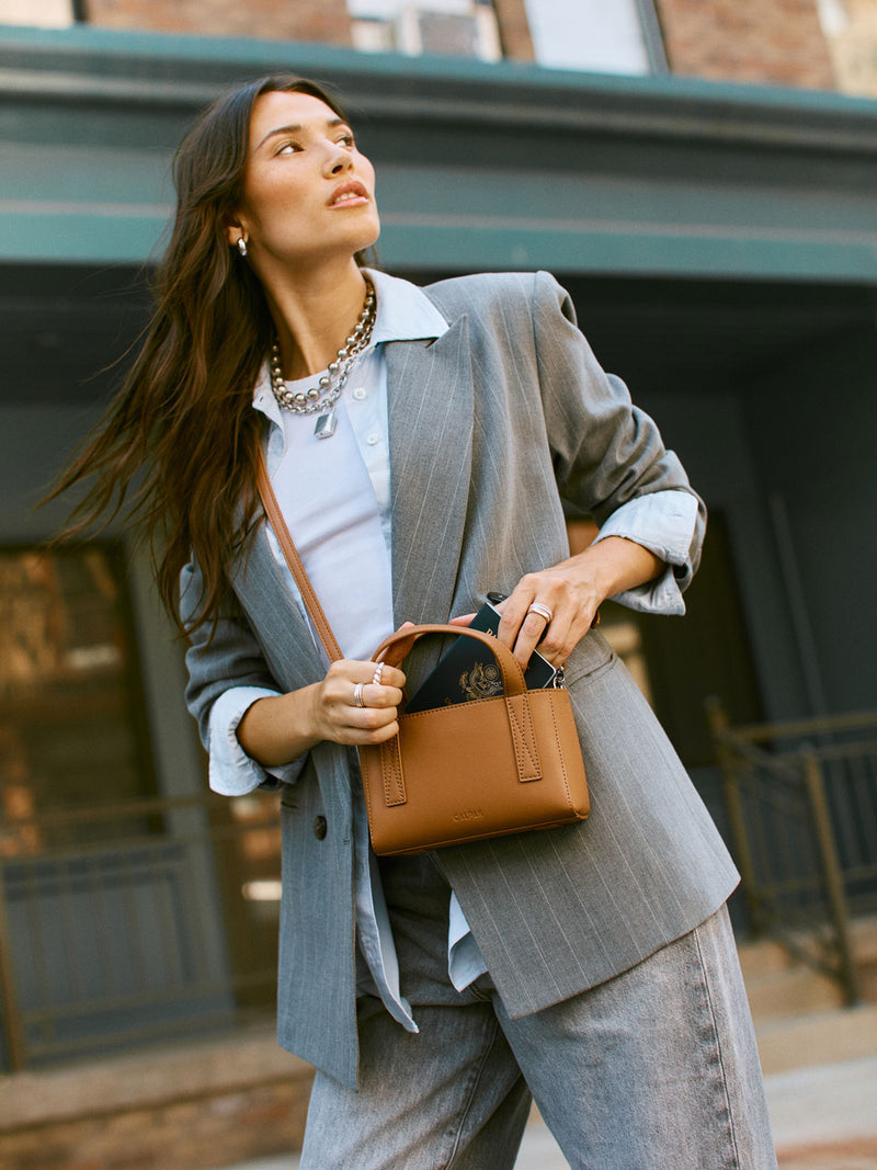 CALPAK Haven Mini Crossbody Bag in brown Toffee being worn by model