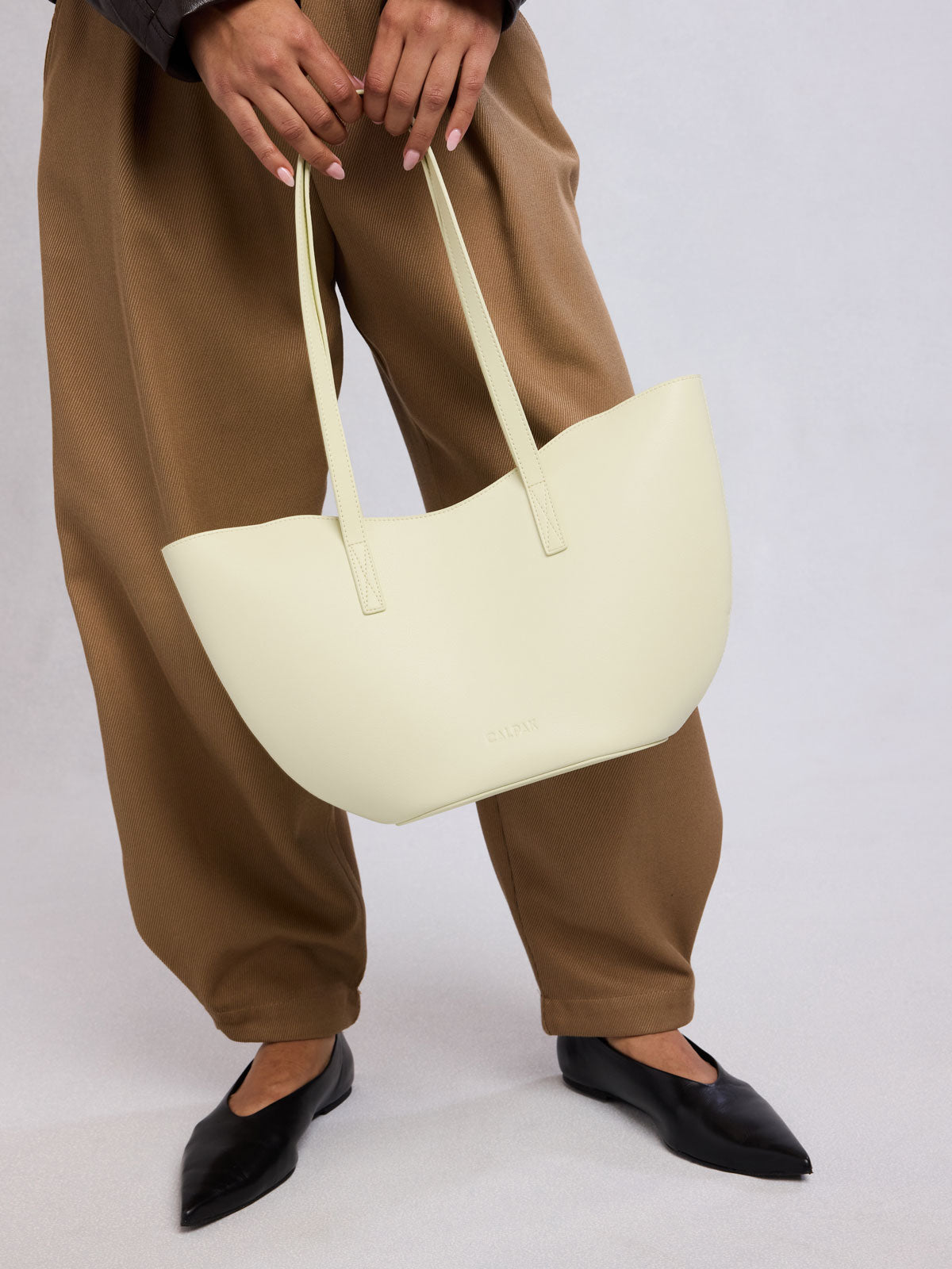 Person holding CALPAK Haven Tulip Tote in light green Celadon; AHP2601-CELADON