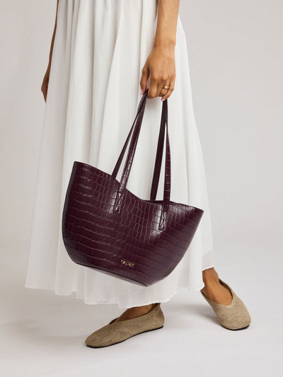 A CALPAK Haven Tulip Tote in Dark Cherry dark plum purple crocodile-embossed leather tote bag with double shoulder straps  against a plain white background ; AHP2601-DARK-CHERRY-FAUX-CROC view 2