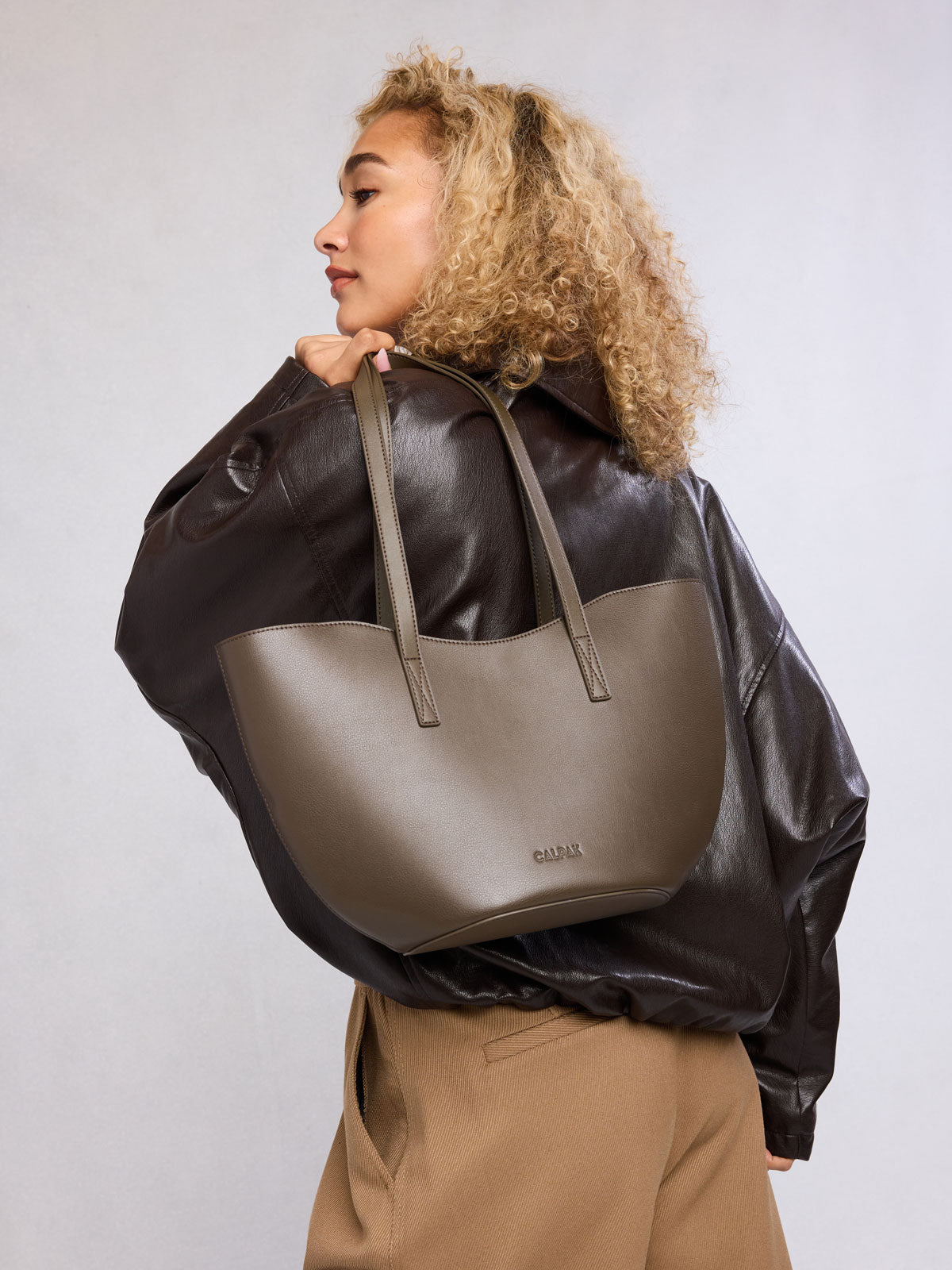 Woman with CALPAK Haven Tulip Tote in brown Mushroom; AHP2601-MUSHROOM