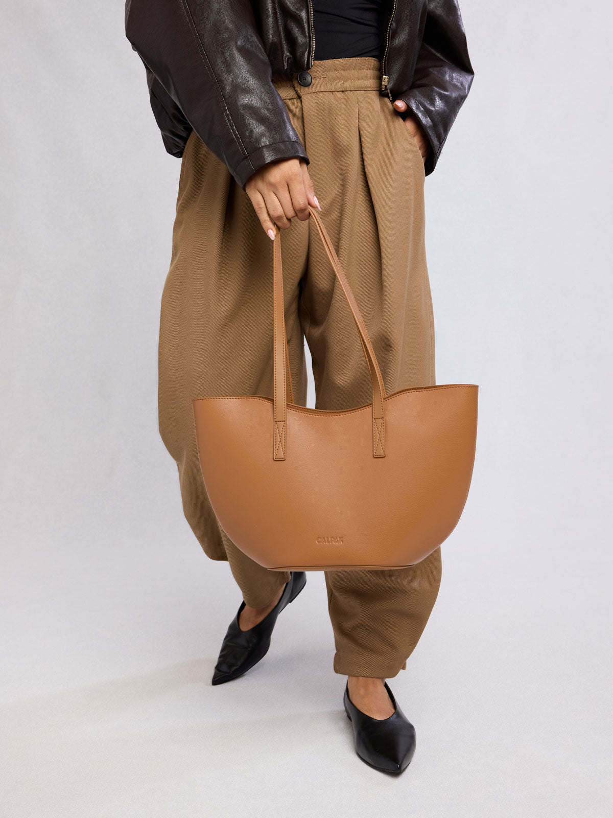 Person holding CALPAK Haven Tulip Tote in light brown Toffee; AHP2601-TOFFEE