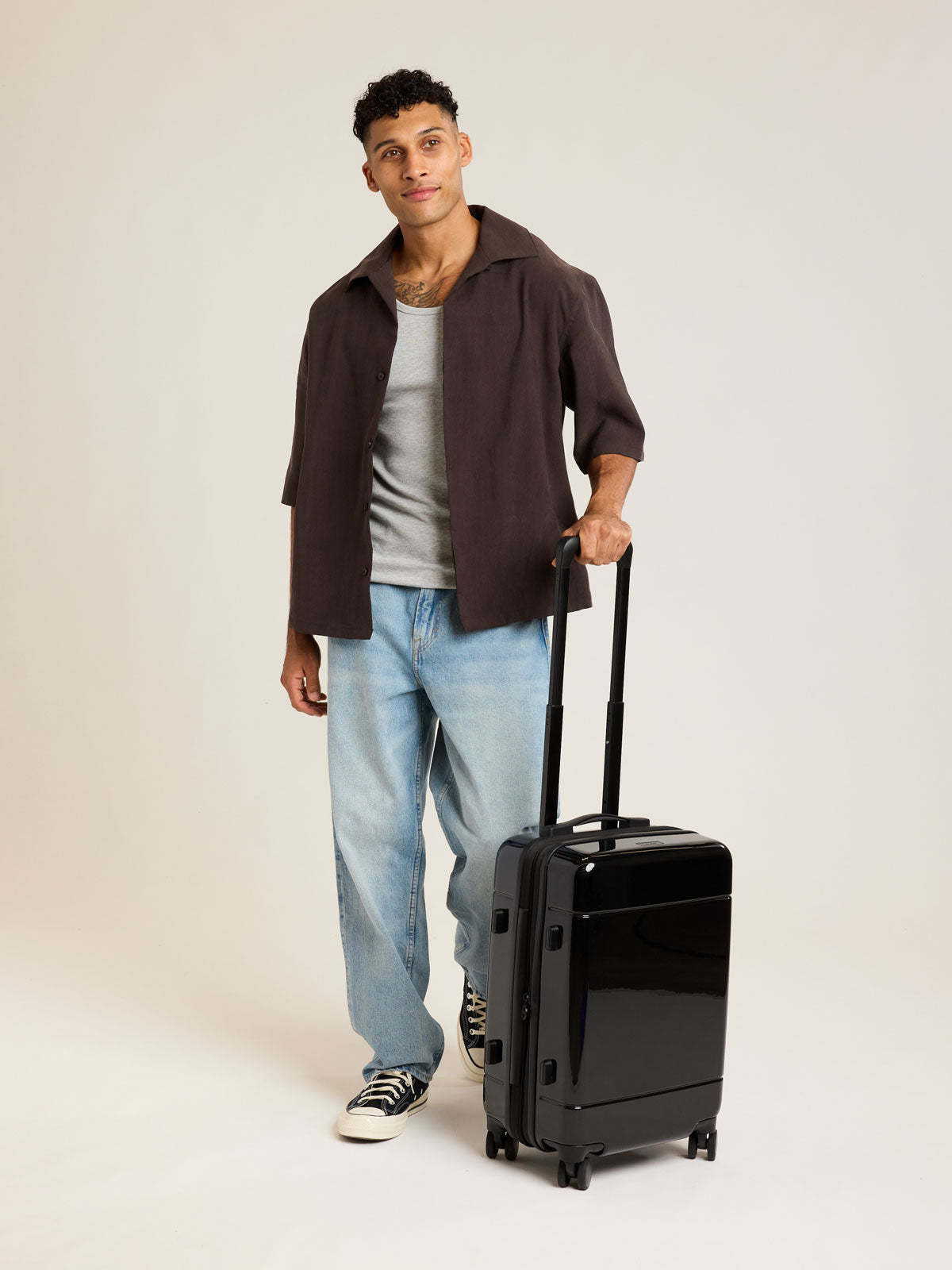 Model with CALPAK Hue Carry On Luggage in Glazed Black opened view on white background; LHU1020-NP-GLAZED-BLACK