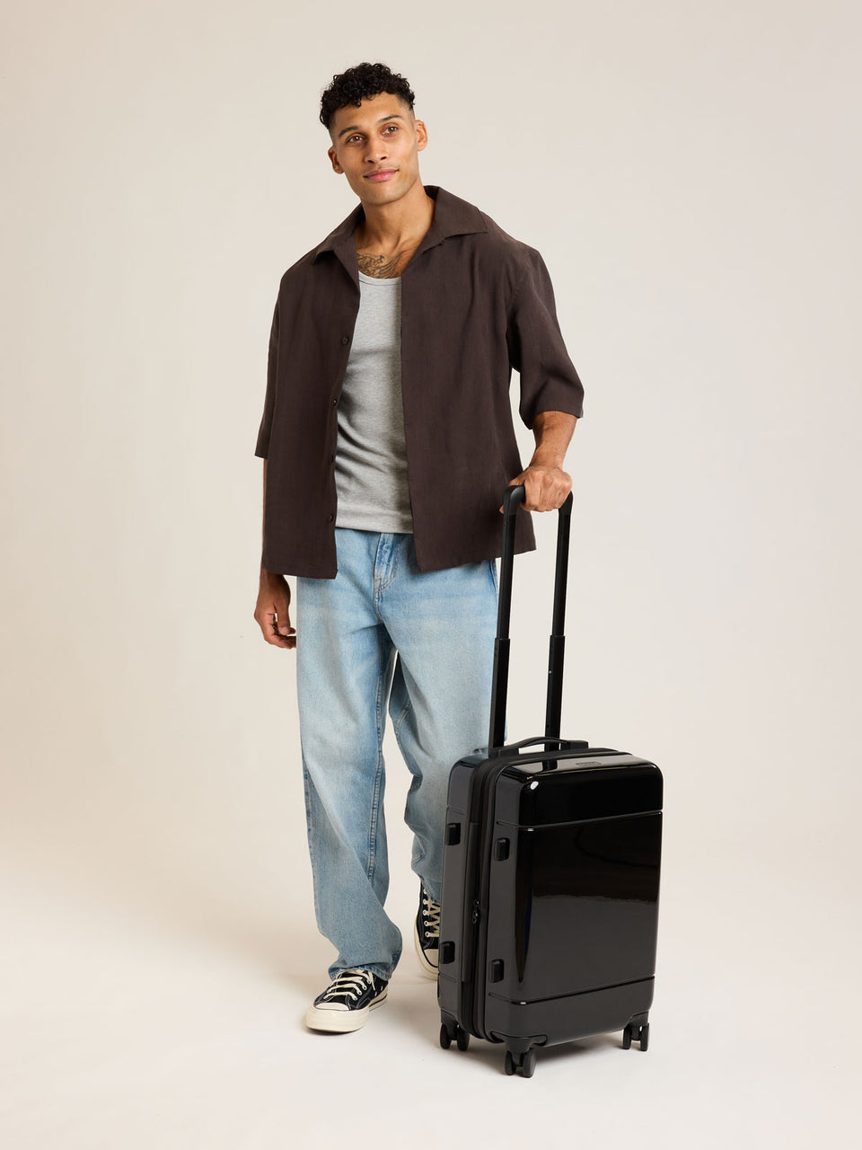 Model with CALPAK Hue Carry On Luggage in Glazed Black opened view on white background; LHU1020-NP-GLAZED-BLACK