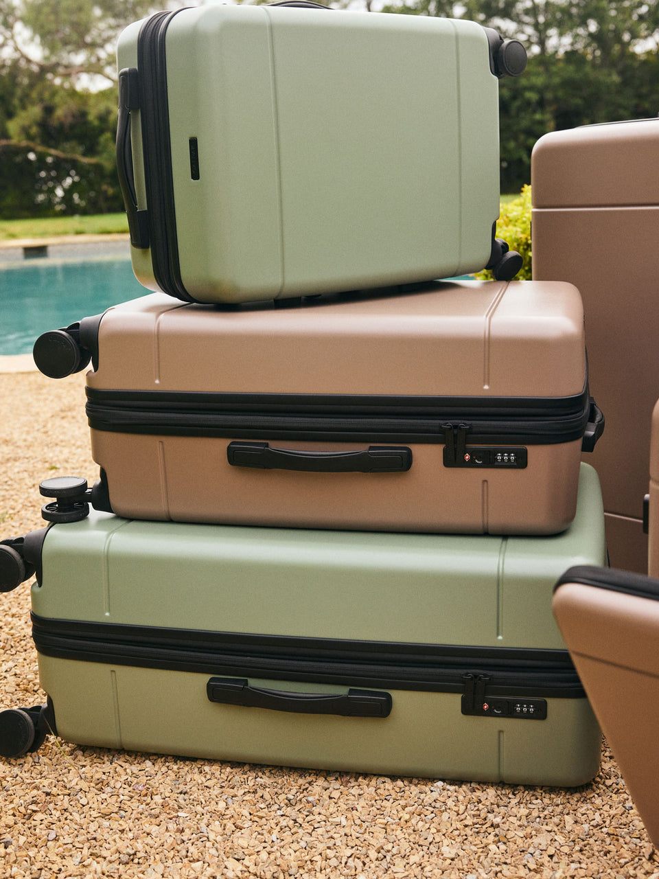  CALPAK Hue Medium Luggage in green Juniper and brown Chocolate stacked on top of each other; LHU1024-CHOCOLATE